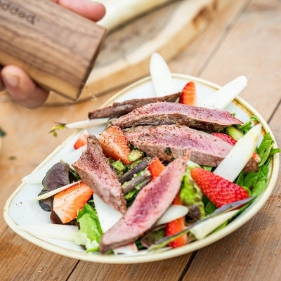 Jelení hřbet na čerstvém salátu z chřestu a jahod s tmavě červeným Kampotským pepřem